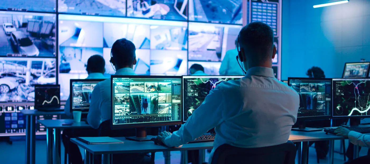 employees observing surveillance camera feeds from a control center