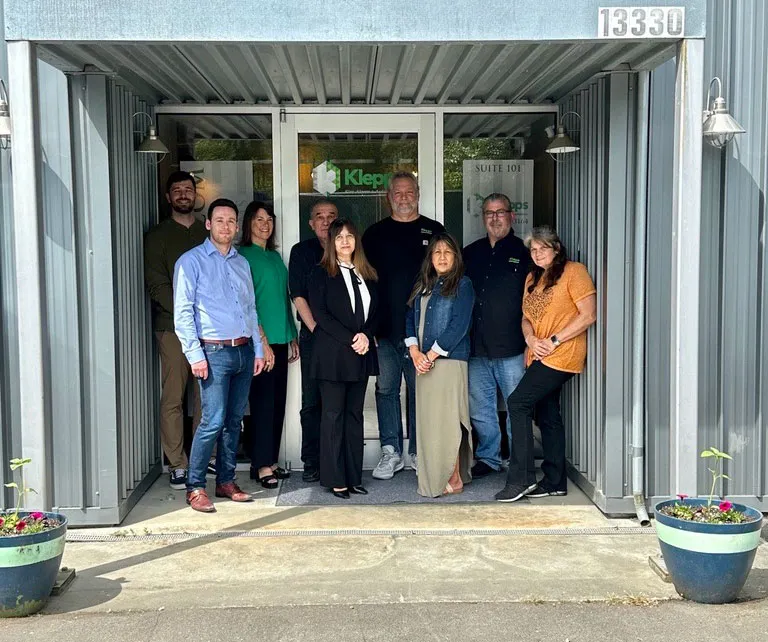 Klepps team standing in front of building front door